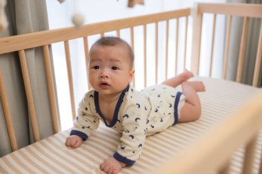 Bebek beşikte sürünüyor ve oynuyor