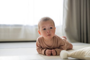 Tatlı bebek yumuşak iç mekanda yerde sürünüyor.