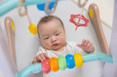 Sevimli bebek, renkli oyuncaklarla eğleniyor.