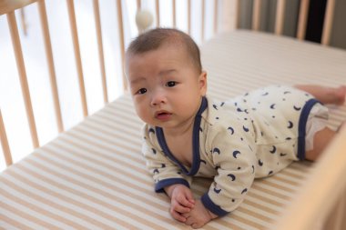 Küçük bebek beşiğinde sürünüyor.