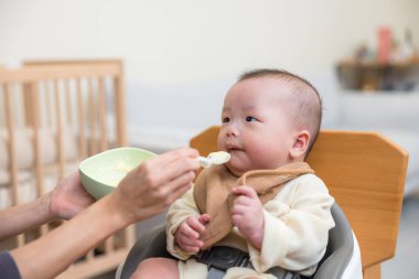 Sevimli bebek kaşıktan yiyor.