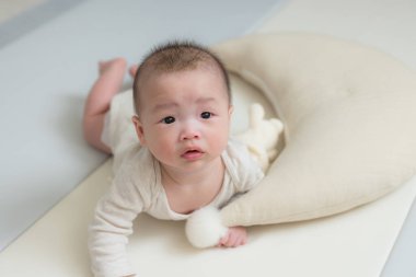 Tatlı bebek yumuşak beyaz yatakta yatıyor.