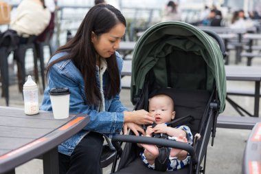 Bebek arabasında bebeğe anne bakıyor.