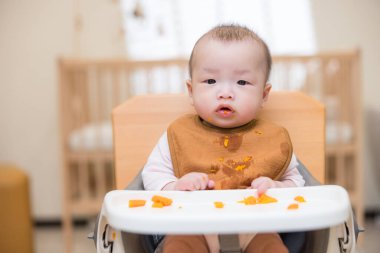Bebek kaseyle yalnız yemeyi öğreniyor.
