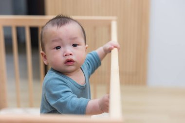 Mutlu bebek beşiğinde durmayı öğreniyor.