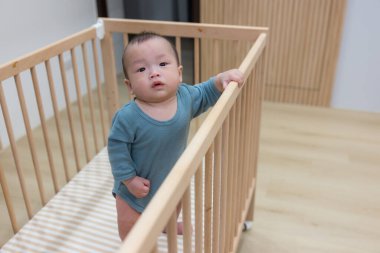 Bebek beşiğinde duran meraklı bebek