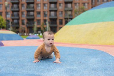 Yumuşak mavi oyun alanı yüzeyinde yatan bebek