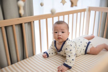 Sevimli bebek ahşap beşiğin içinde yavaşça hareket ediyor