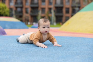 Bebek renkli oyun alanı yüzeyinde sürünüyor