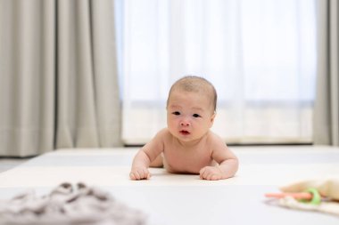 Sevimli bebek, karnının üstünde yatıyor.