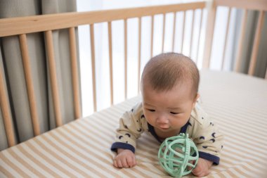 Sevimli bebek beşikte oyuncakla oynuyor