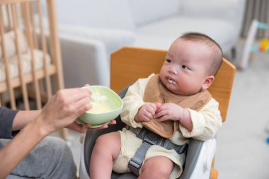 Bebek annesiyle yemek yemeyi öğreniyor.