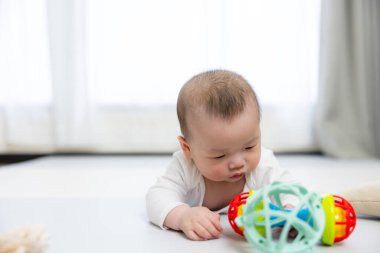 Sevimli bebek renkli oyuncaklarla oynuyor.