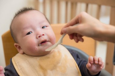 Ebeveynler bebeği sağlıklı yumuşak yiyeceklerle besler.
