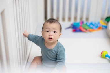 Küçük bebek beşiğinde meraklı görünüyor