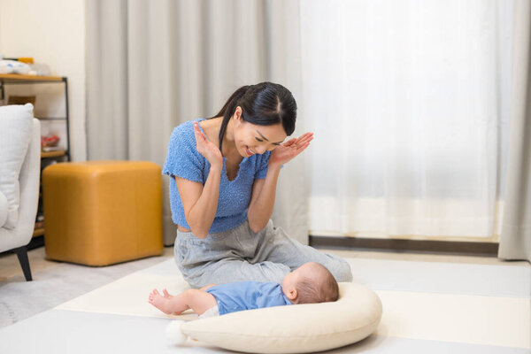Loving mother playing with baby happily at home