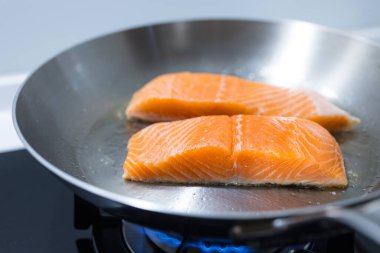 Taze somon filetosu kızartma tavasında pişiyor.