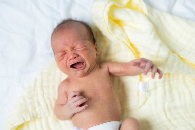 Yeni doğmuş bebek gözleri kapalı ağlıyor.