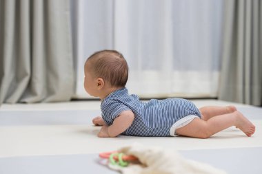 Minik yeni doğmuş bebek yumuşak bir emekleme paspasında