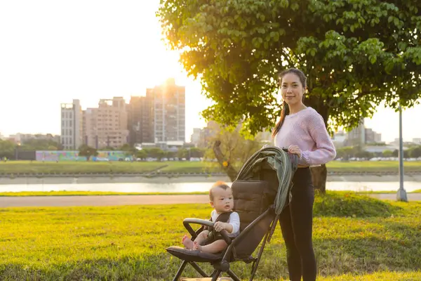 Bebek arabasında bebeği olan bir anne.