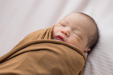 Battaniyeye sarılmış tatlı bebek uyuyor.