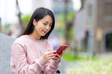 Şehirde yürürken cep telefonu kullanan şık bir kadın.