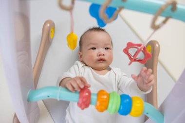 Bebek yerde yatar ve oyuncakları kapar