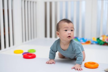 Yumuşak oyun minderinde emekleyen tatlı bebek.