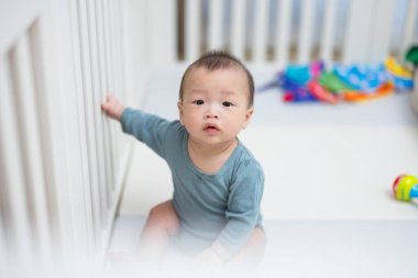 Güvenli oyun parkında oturan şirin bebek.