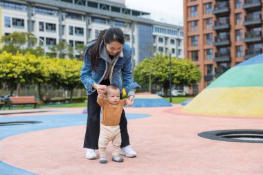 Mutlu anne, bebeğe destek oluyor.