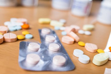 Kahverengi masaya dağılmış reçeteli ilaçlar.