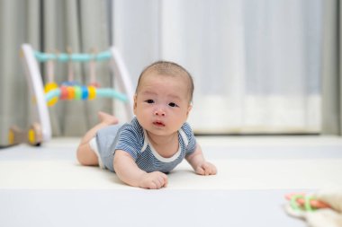 Tatlı bebek yumuşak oyun hasırının üzerinde uzanıyor.