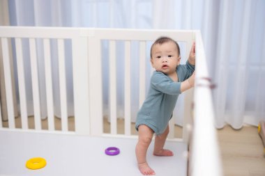 Çocuk parkında durup kameraya bakan meraklı bebek.