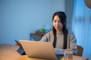 Akşam saatlerinde dijital cihazla çalışan bir kadın