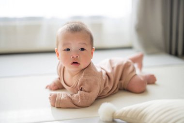 Yerde yatan tatlı bebek meraklı görünüyor.