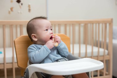 Evde pirinç krakeri yiyen şirin bir bebek.