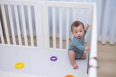 Bebek çocuk oyun parkının içinde durmaya çalışıyor.