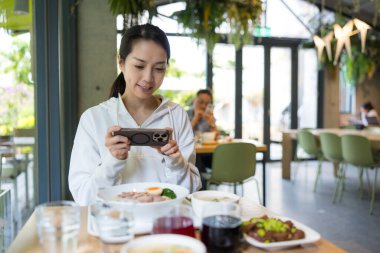 Restoran Masasında Telefonla Yemek Fotoğrafı Çeken Kadın