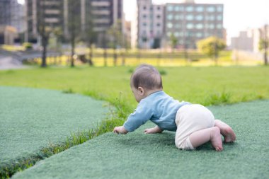 Mutlu bebek yeşil çimenlerde özgürce sürünüyor