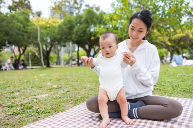 Anne ve bebek parkta piknik yapıyorlar.