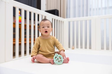 Evde Oyuncak ile Evde Oturan Asyalı Bebek