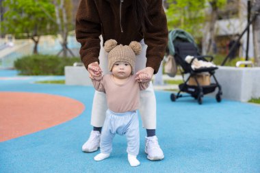 Anne bebeğe yol gösteriyor oyun alanının dışına ilk adımları