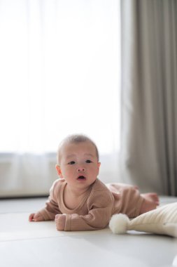 Evdeki oyun parkında bebek sürünüyor.