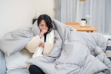 Kalın bir battaniyeye sarılmış hasta bir kadın