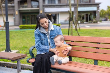 Anne ve oğlu yeşil parkta birlikte dinleniyorlar.
