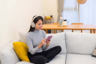 Kadın Kulaklıkla Cep Telefonu ile Müzik Dinliyor