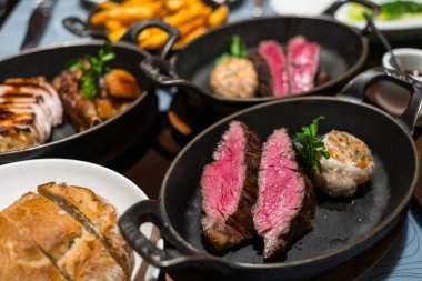 Demir tabakta dilimlenmiş sulu biftek.