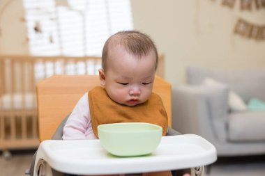 Tatlı bebek sessizce oturup yemek bekliyor.