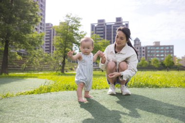 Genç Anne oğlunu dışarı oyun parkına götürüyor.