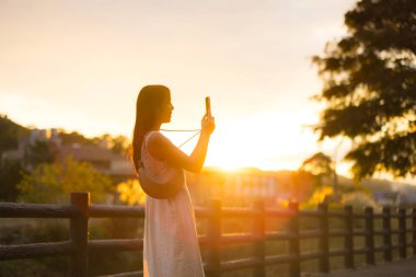 Cep telefonuyla fotoğraf çeken bir kadının arka planı